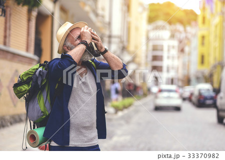 Calm senior man using camera in city 33370982