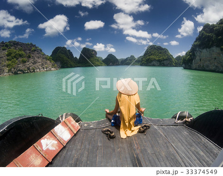 man wearing Vietnamese hat in Ha Long bay man wearing Vietnamese hat in Ha Long bay 33374549