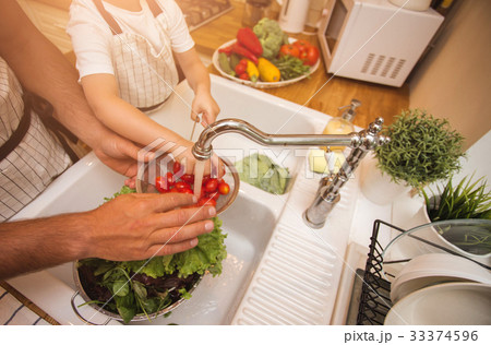 Father with son washes vegetables before eating 33374596