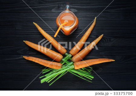 Carrot juice in a glass jar with handle on  table 33375700