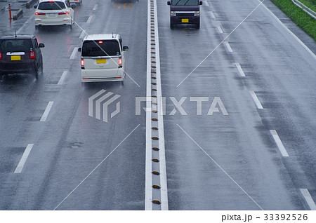 雨の日の運転 片側二車線 国道の濡れた路面 俯瞰ヨコの写真素材