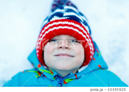 Happy kid boy having fun with snow in winter Happy kid boy having fun with snow in winter 33395920