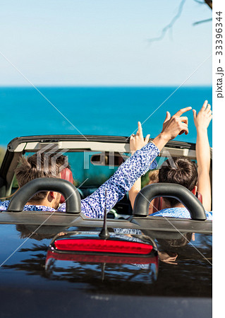 Group of happy young friends in cabriolet with 33396344