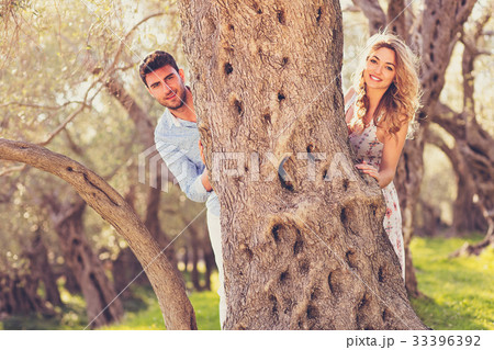 Loving young couple standing by trees at olive 33396392