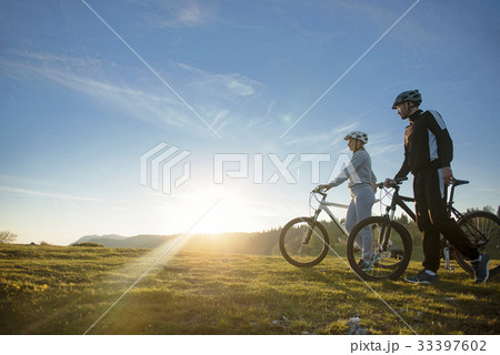 Cyclist couple with mountain bikes standing on the 33397602