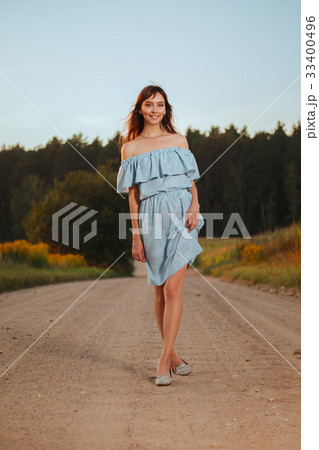 Pretty girl walking on country road in sunset Pretty girl walking on country road in sunset 33400496