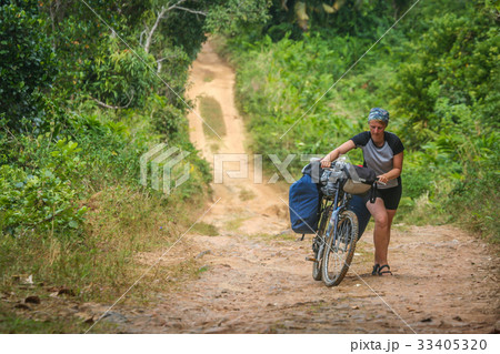 Pushing bicycle on a jungle path Pushing bicycle on a jungle path 33405320