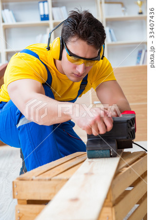 Repairman carpenter polishing a wooden board with 33407436