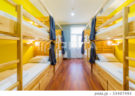 Hostel dormitory beds arranged in room 33407493