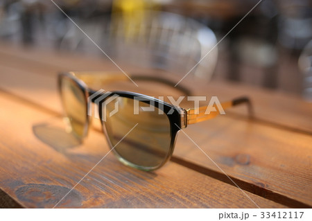 Sunglasses on wooden bench. Close up 33412117