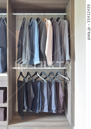 colorful shirts and pants hanging in wardrobe 33412439