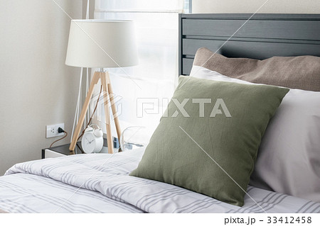modern bedroom with green pillow and wooden lamp 33412458