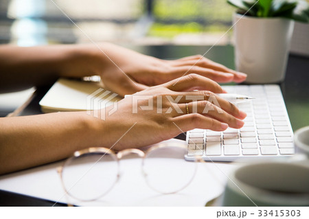 Typing and working on the table at workplace Typing and working on the table at workplace 33415303
