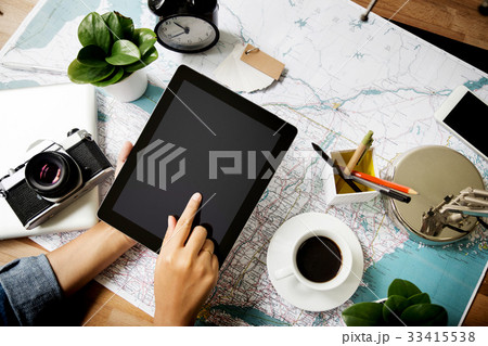 Touching tablet device above map at work place Touching tablet device above map at work place 33415538