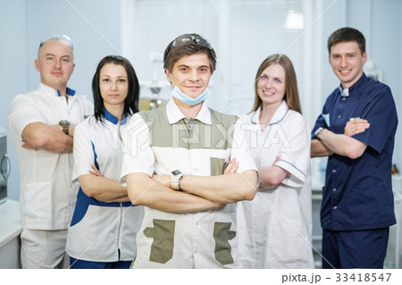 Group of dentists standing in their office and 33418547
