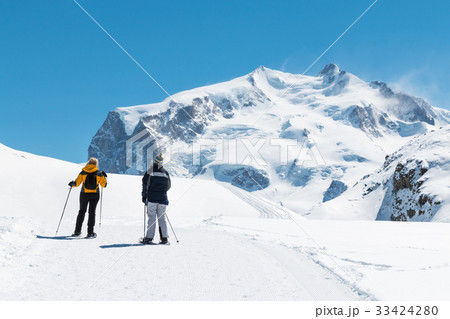 two people are trekking on the snow mountain 33424280