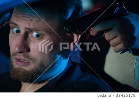 Criminal person pointing gun at the driver 33425179