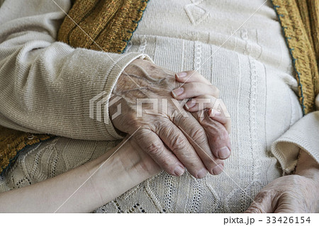 wrinkled hand holding a younger hand 33426154