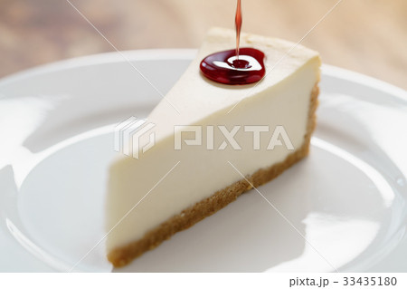 pouring berry jam on slice of traditional new york 33435180