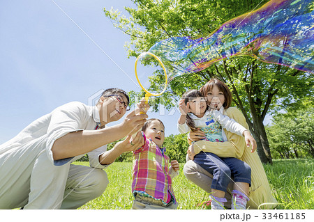 新緑の公園で遊ぶ4人家族の写真素材