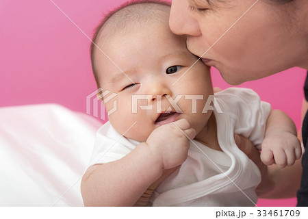 赤ちゃんに口づけする母親 33461709