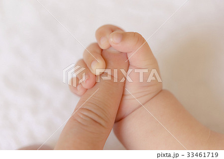 大人の指を握る赤ちゃんの手の写真素材