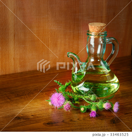 Oil and flowers of milk thistle on wooden 33463525