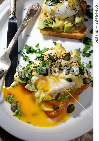 Eggs Benedict with avocado on toast Eggs Benedict with avocado on toast 33464405
