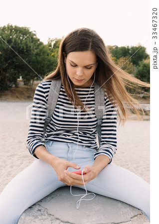 Beautiful girl in a T-shirt listening to music 33467320