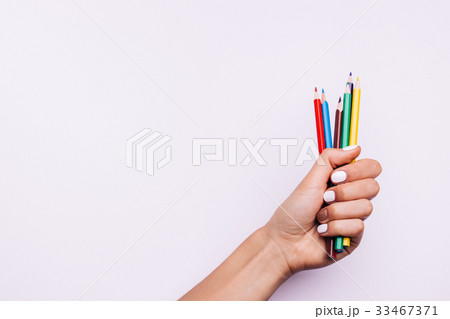 Multi-colored pencils in a female hand 33467371