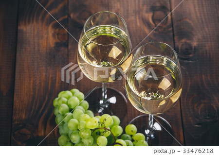 Beautiful White wine in glass with a bunch grapes Beautiful White wine in glass with a bunch grapes 33476218