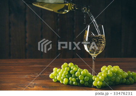 Beautiful White wine in glass with a bunch grapes 33476231