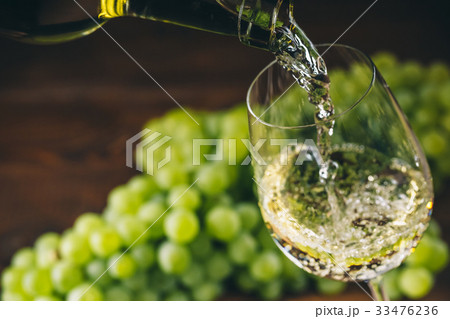Beautiful White wine in glass with a bunch grapes 33476236