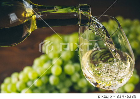 Beautiful White wine in glass with a bunch grapes 33476239