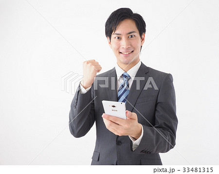 スマートフォンを見てガッツポーズをするビジネスマン スマートフォンを見てガッツポーズをするビジネスマン 33481315