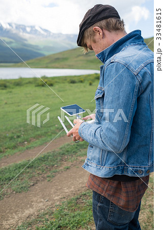 Man controling a drone on landscape background  33481615