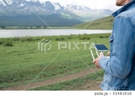Man controling a drone on landscape background  33481616