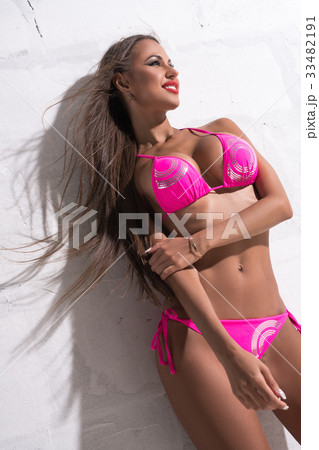 Gorgeous brunette against white wall sunny shot 33482191