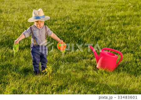 One year old baby boy using watering can 33483601