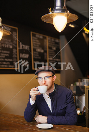 man in the coffee shop in glasses drinking coffee 33483957