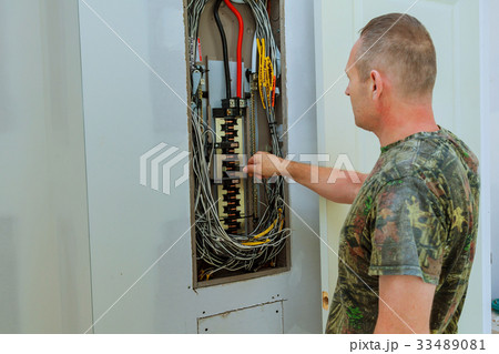 Professional electrician installing components Professional electrician installing components 33489081