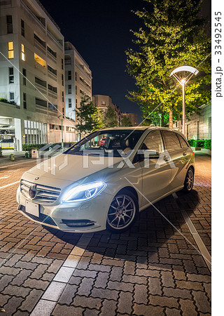 白い車と夜の街並み風景の写真素材