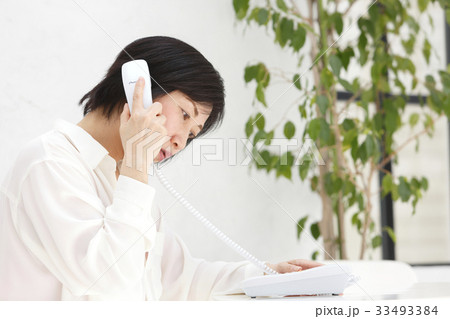 固定電話で話す女性 固定電話で話す女性 33493384