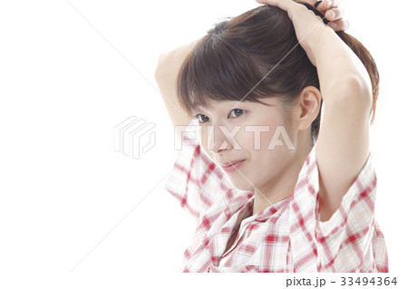 髪を束ねる女性の写真素材