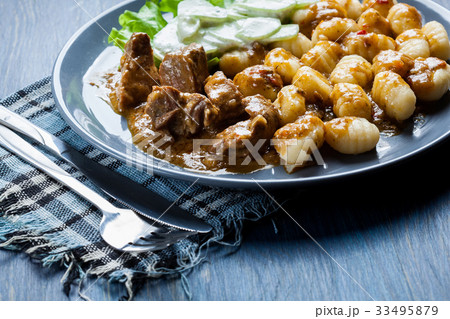 Italian potato dumplings with stew and salad 33495879