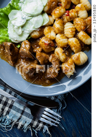 Italian potato dumplings with stew and salad 33495880