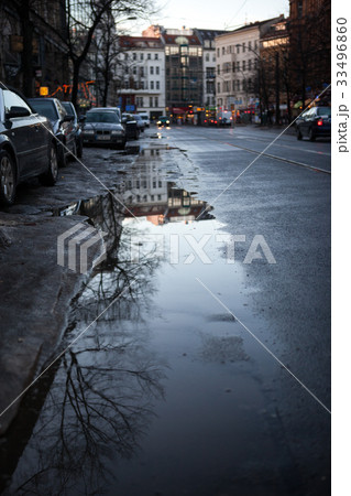 puddle on the road with reflection of trees in the 33496860
