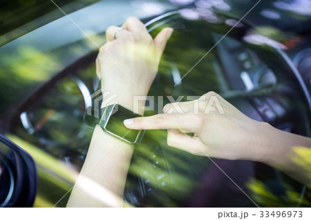 A woman uses smartwatch in the car. 33496973