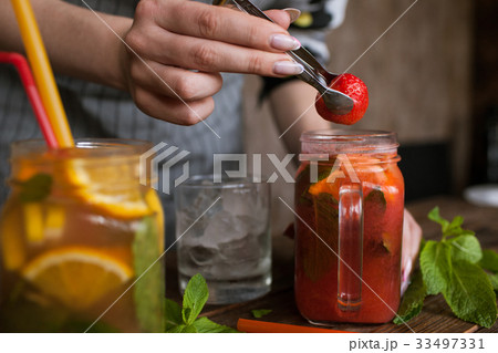 Waiter preparing strawberry cocktail in restaurant Waiter preparing strawberry cocktail in restaurant 33497331