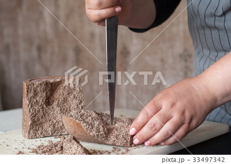 Cook breaks off piece of aerated chocolate 33497342